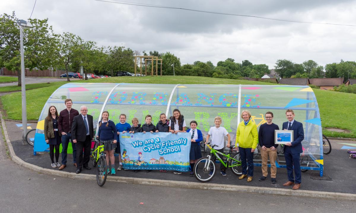 adults and children with poster of cycle friendly school banner