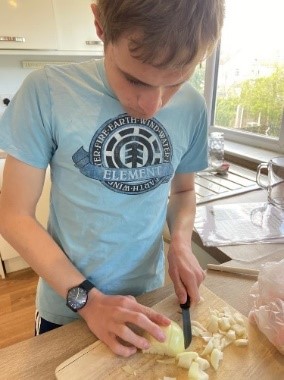boy in kitchen cutting onions