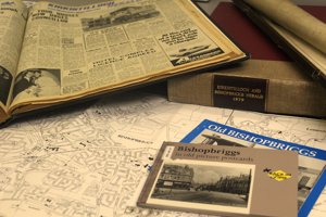 An array of old newspapers spread across a desk