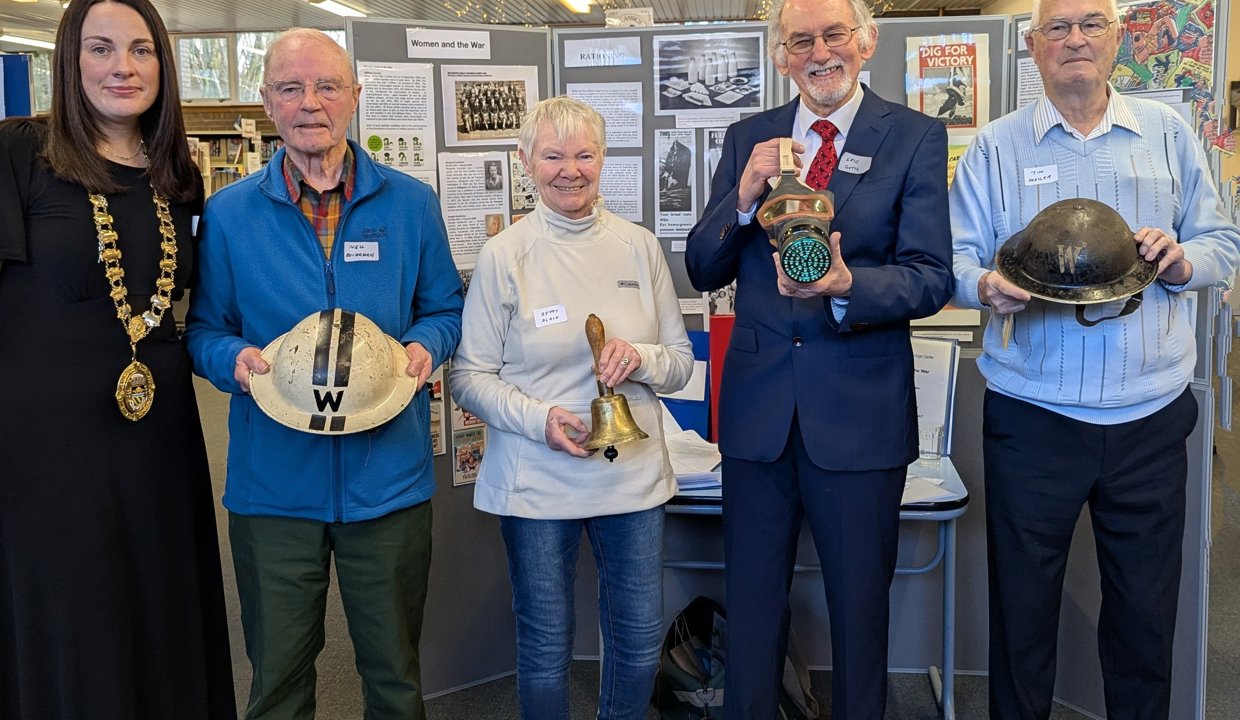 Depute Provost Colette McDiarmid in Milngavie Library standing with four other peoples holding artefacts