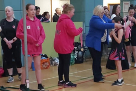 Provost presenting medal to netball player