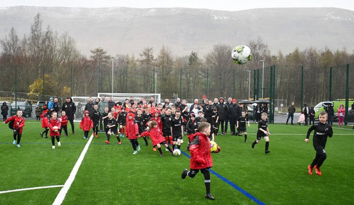 Kids playing football on the new pitch in Lennoxtown