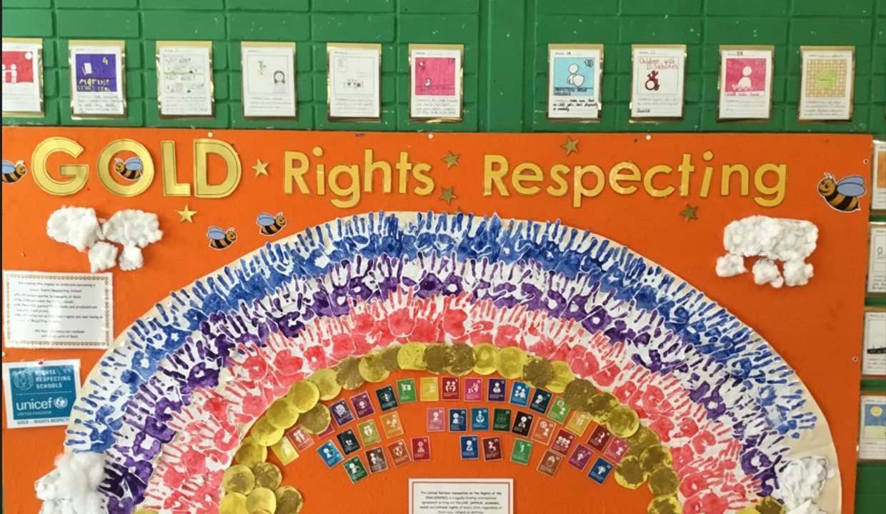 A photo of a display at the school celebrated its Gold Award - featuring a rainbow, artwork and text