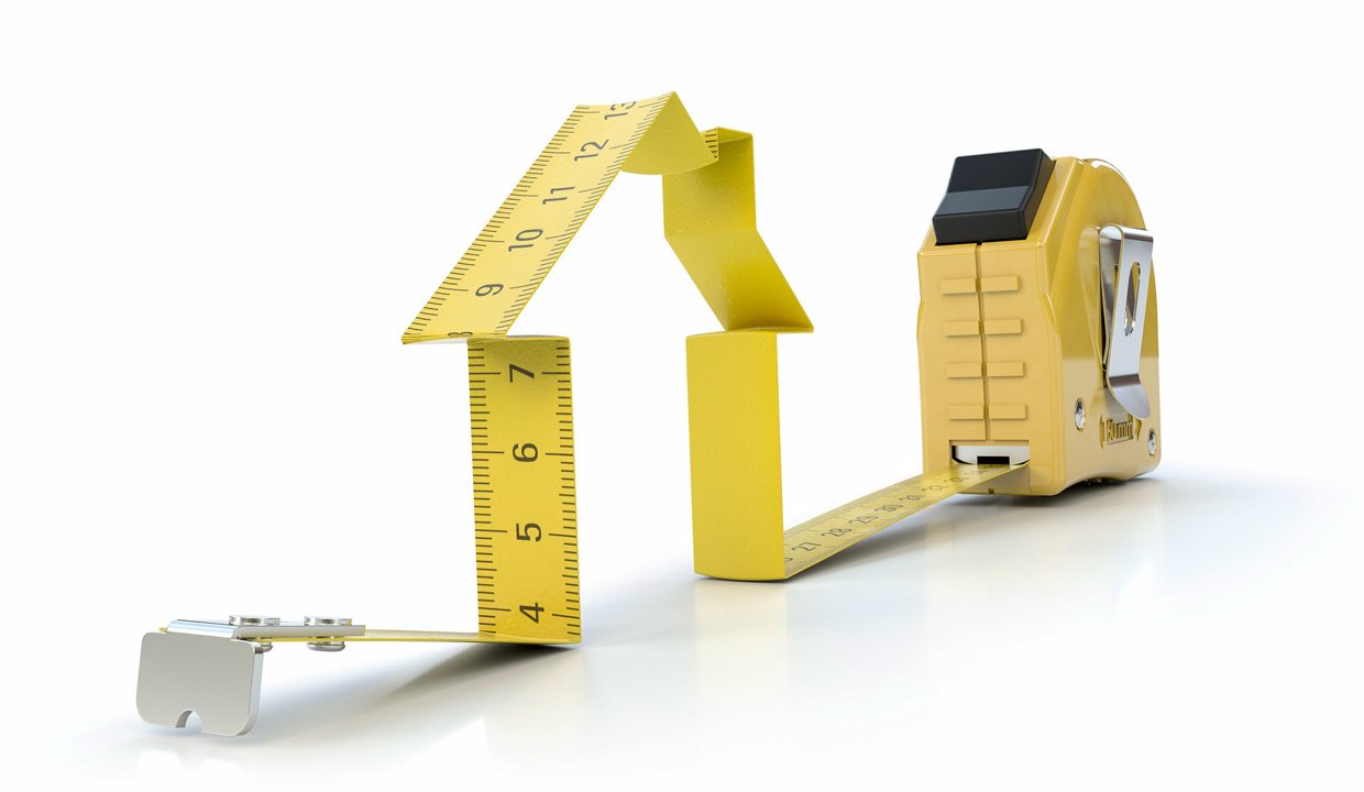 Yellow measuring tape forming the shape of a house