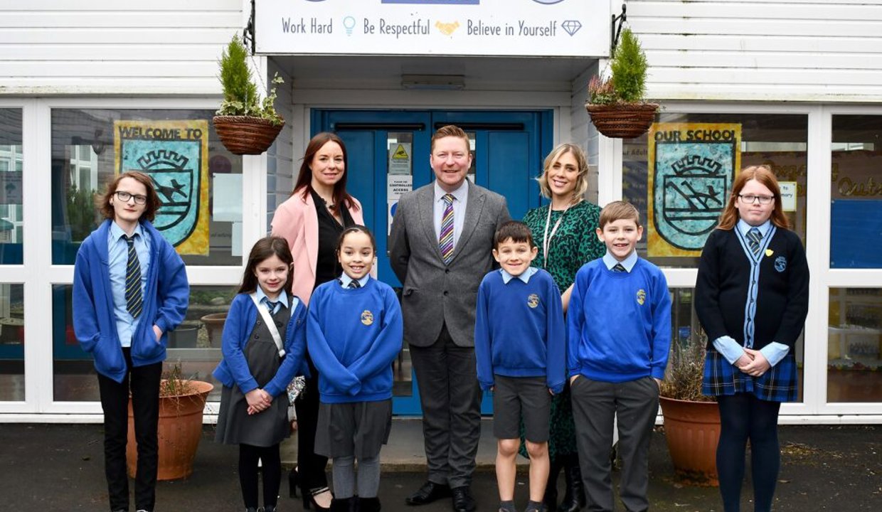 Mrs Bremner outside oxgang Primary school with two staff members and six children