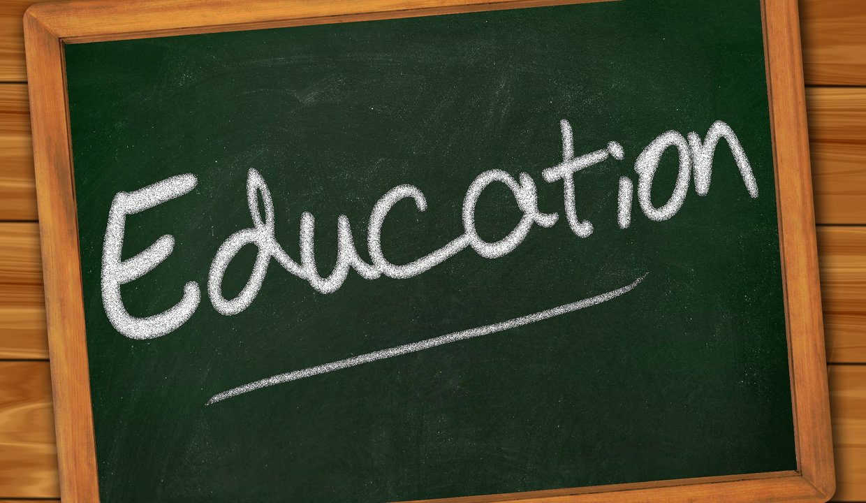 black board with education wrote on it in chalk on a wooden background