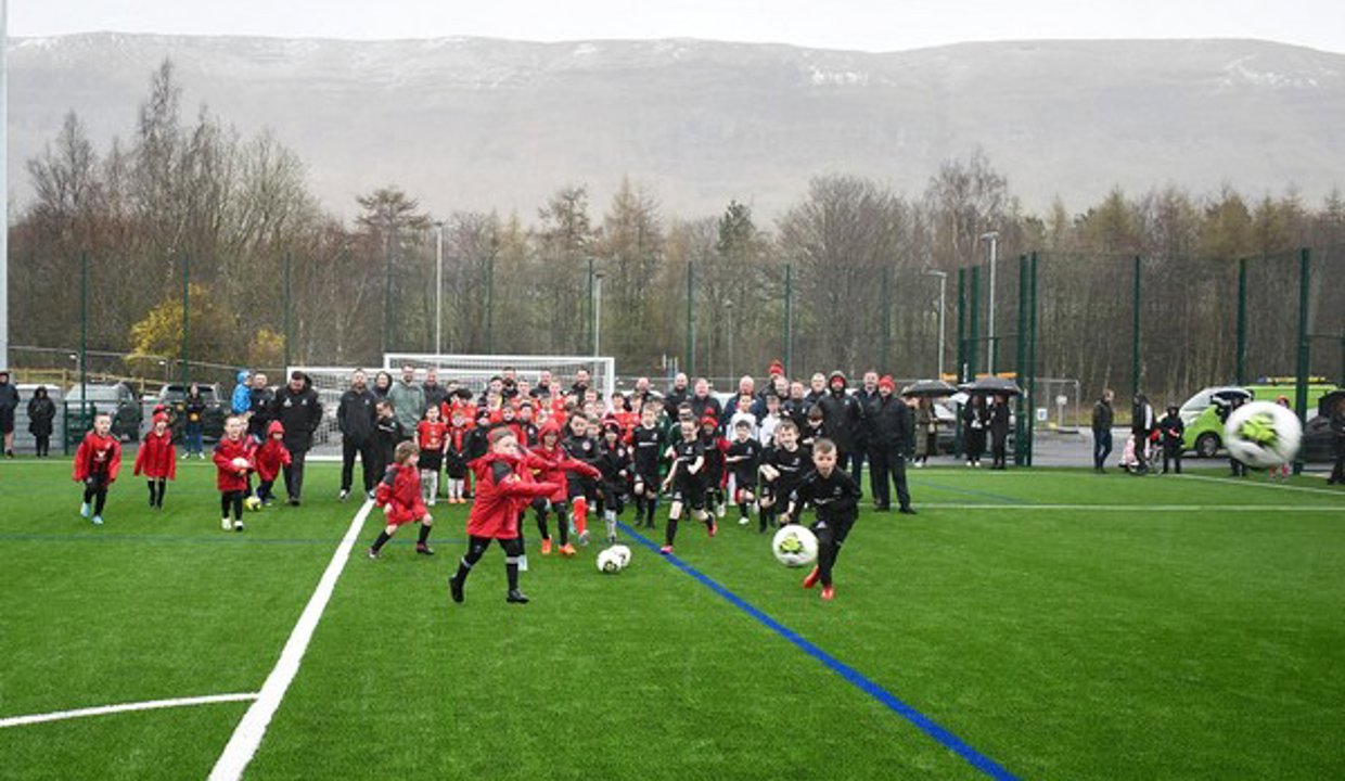 Kids playing football on the new pitch in Lennoxtown