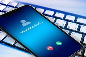 a mobile phone with the words “incoming call” and a keyboard