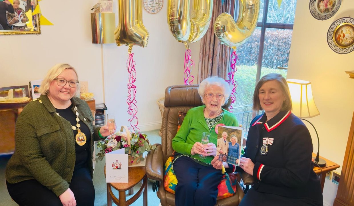 Provost Gillian Renwick sitting with Agnes Jenkins. Gold 105 birthday balloons behind them