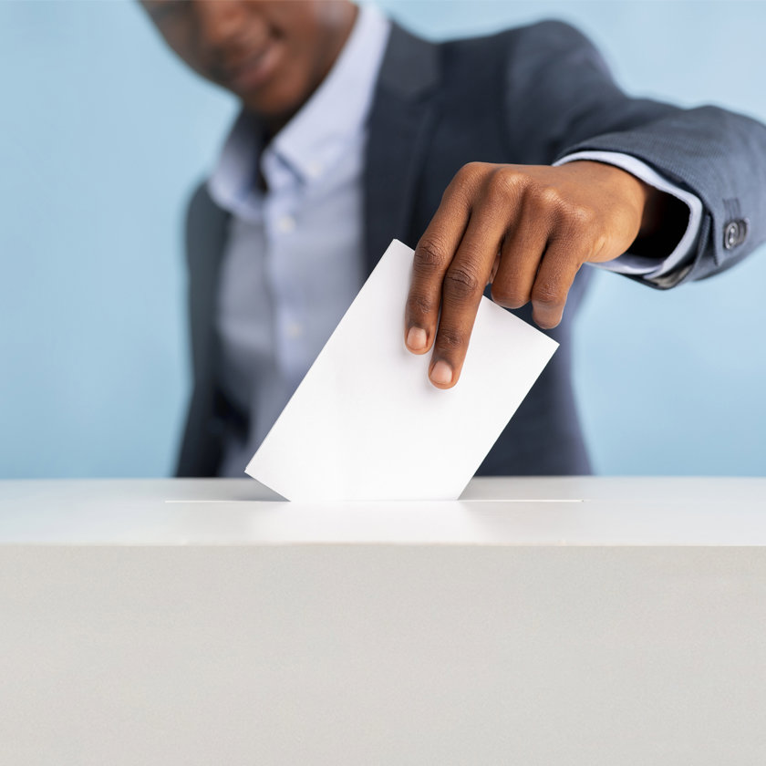 Person putting a ballot paper into the ballot box