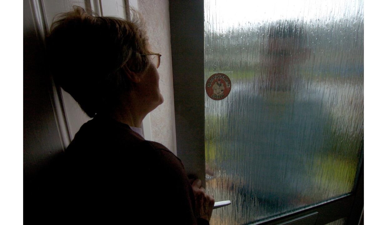 Woman at front door with cold caller on door step