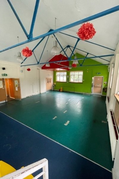 mail hall with green and blue flooring and white walls and blue beams at ceiling height