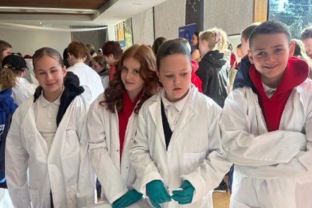 People wearing white lab jackets while taking part in STEM festival