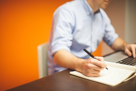 A person is pictured working with a computer to detect fraud