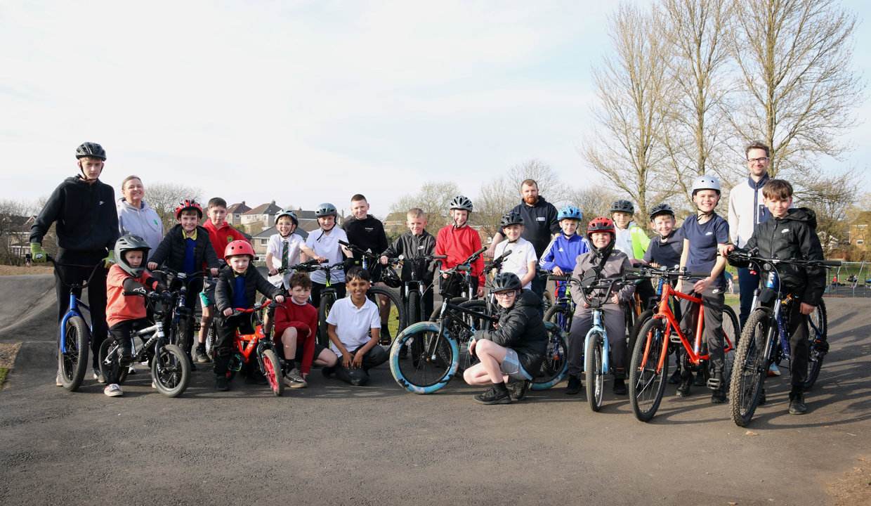 A group of people on bikes on the new pump track