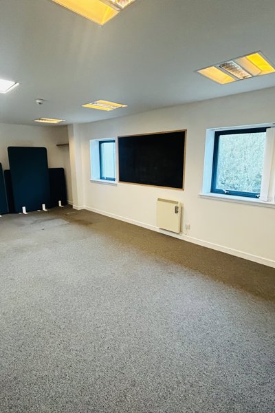 room with small windows and grey carpet and white walls