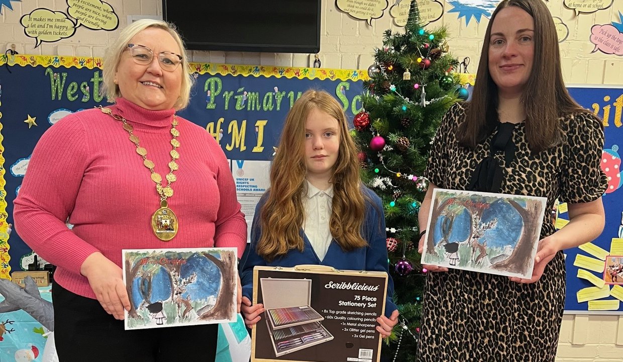 Provost Renwick and Depute Provost Colette McDiarmid with bonnie holding the winning card design