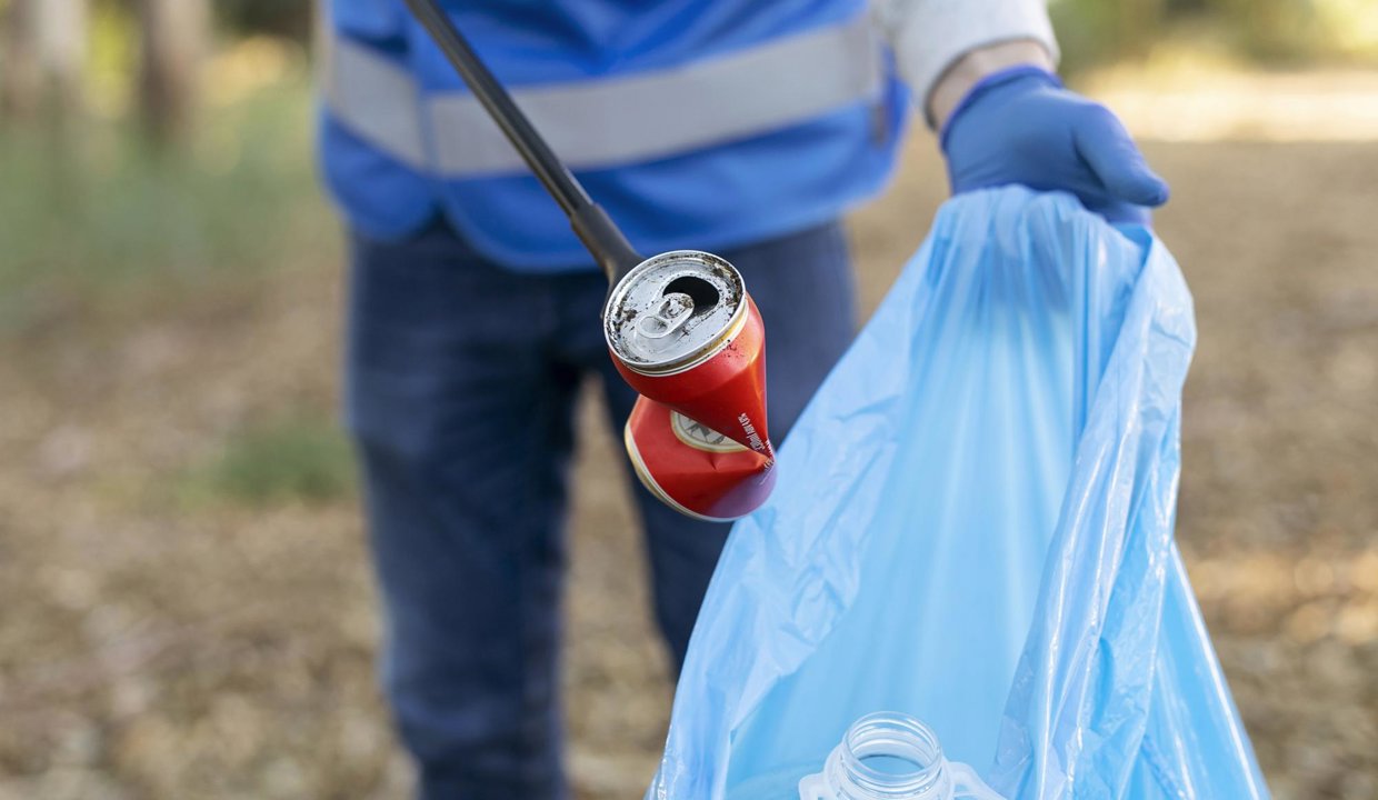 Person adding rubbish to a plastic bag