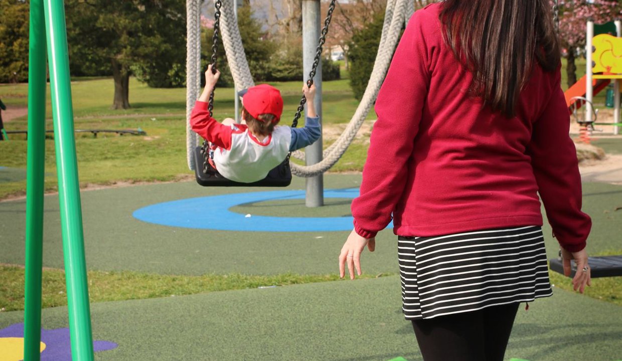 child getting pushed on a swing