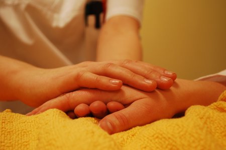 Person placing their hand on someone elses hand
