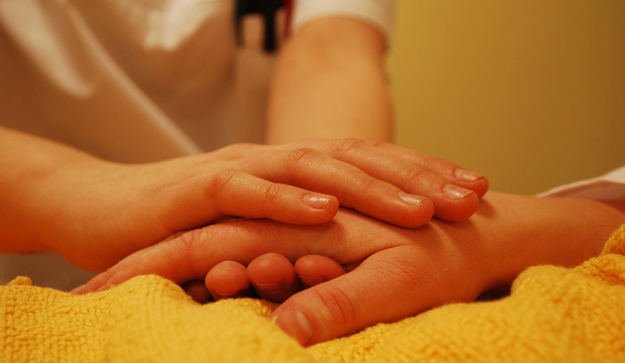 Person placing their hand on someone elses hand