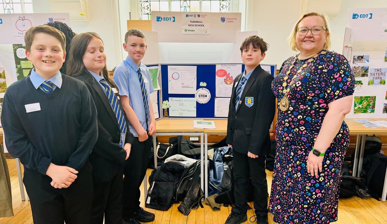 The provost stands with pupils from turnbull in front of their display