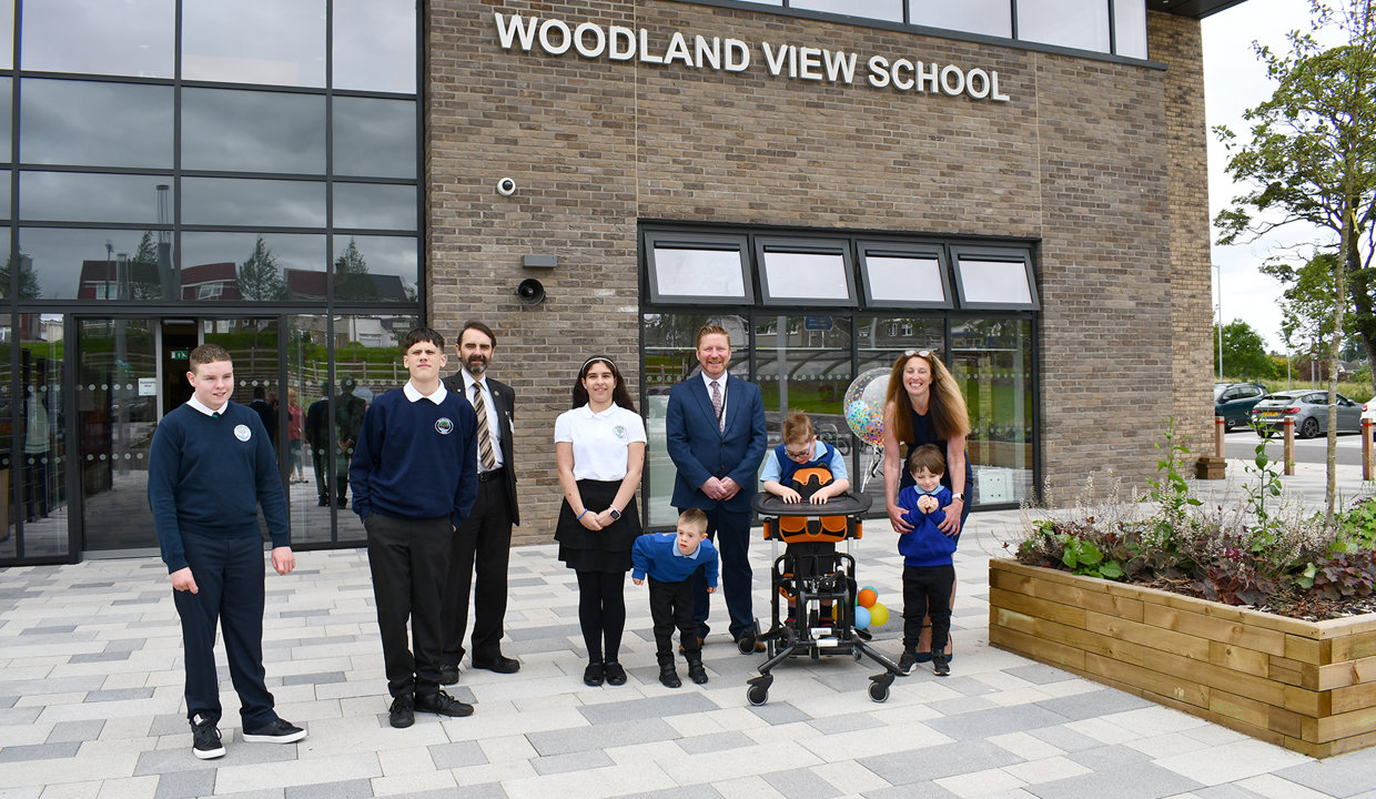 Councillor Gordan Low with Woodland View pupils and head teacher outside the new school building on opening day