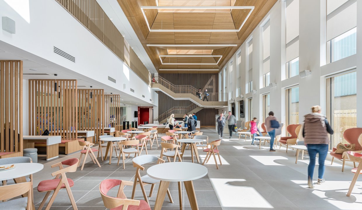 A photo of the interior of the Allander Leisure Centre in Bearsden – showing a café, seating, reception area and people