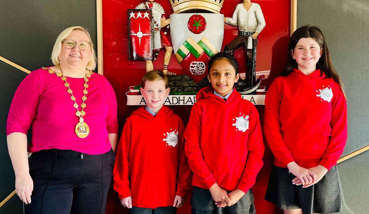 Provost Renwick with Bishopbriggs Youth Ambassadors in front of the Civic crest in the Council Chambers