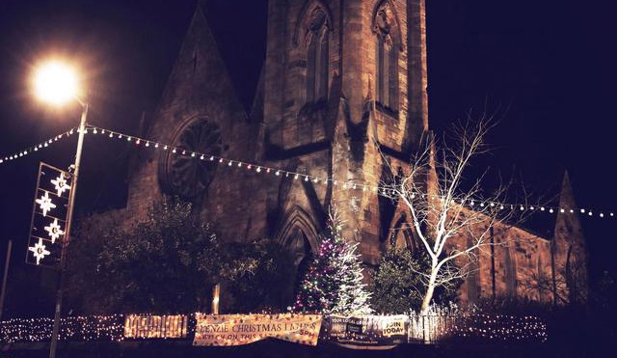 The community Christmas tree in the church grounds surrounded by fairy lights and street decorations