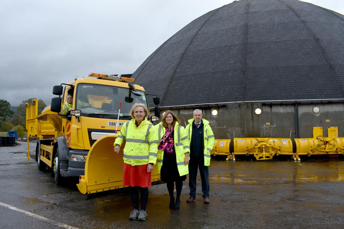 Image of councillor, roads staff and gritter with salt dome in the background