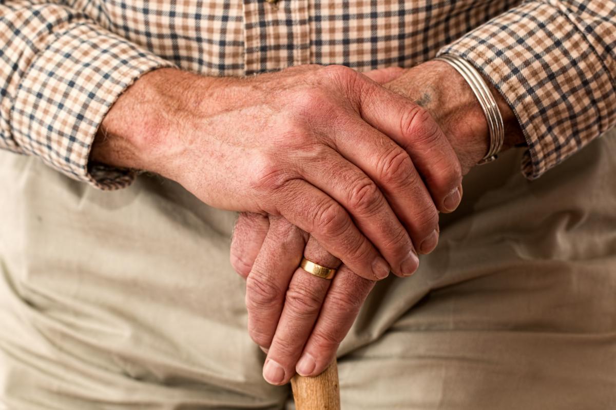 elderly man holding his hands