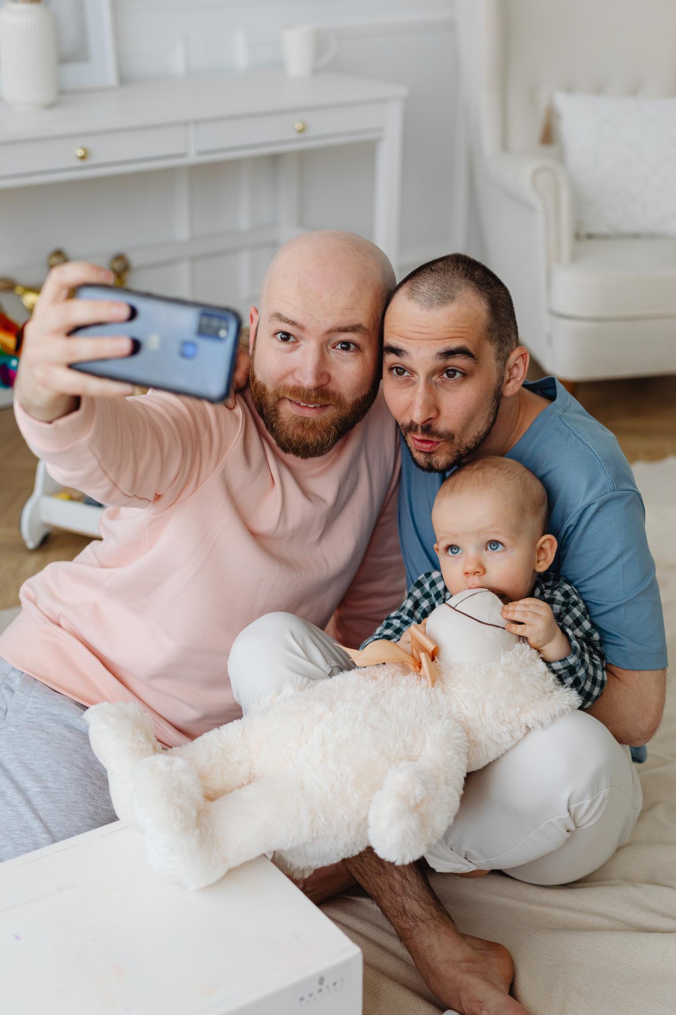 Sam and Ali taking a selfie with their child