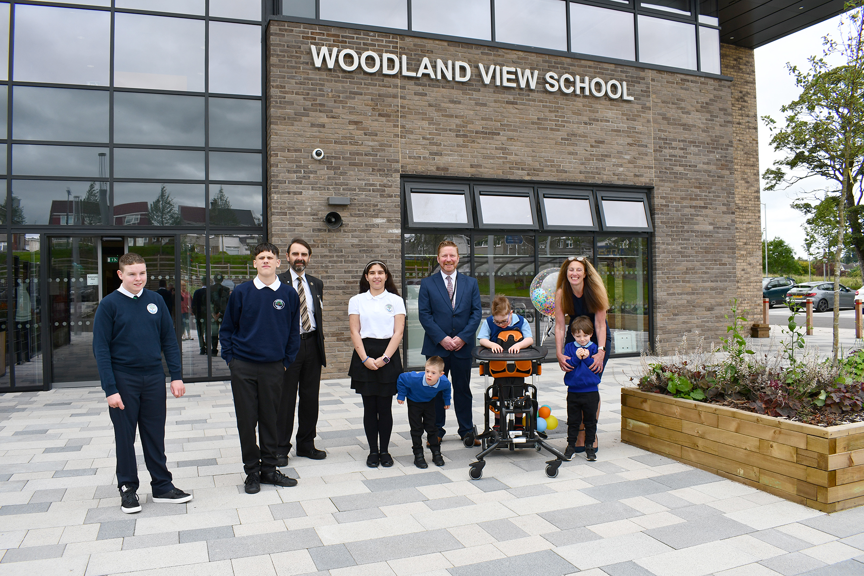 Councillor Gordan Low with Woodland View pupils and head teacher outside the new school building on opening day