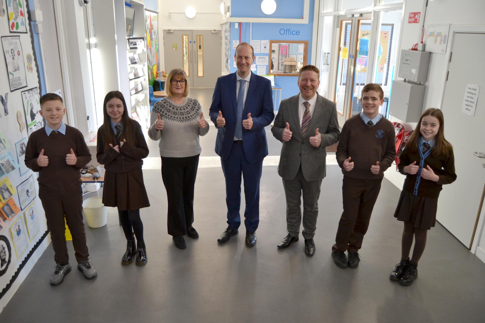 Holy Family pupils and head teacher giving thumbs up with inspectors
