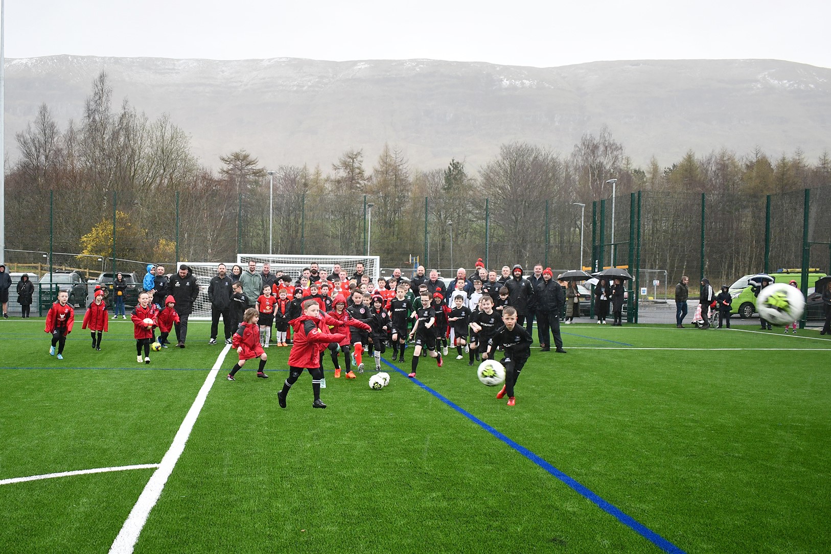 Kids playing football on the new pitch in Lennoxtown