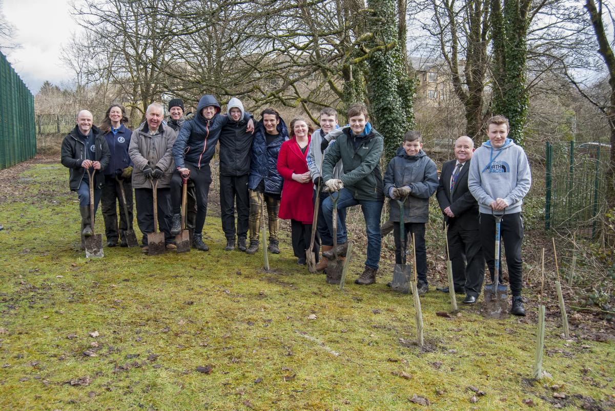 Pupils and adults planting young trees