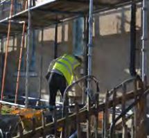 construction worker in a high vis jacket carrying out repair work on a building