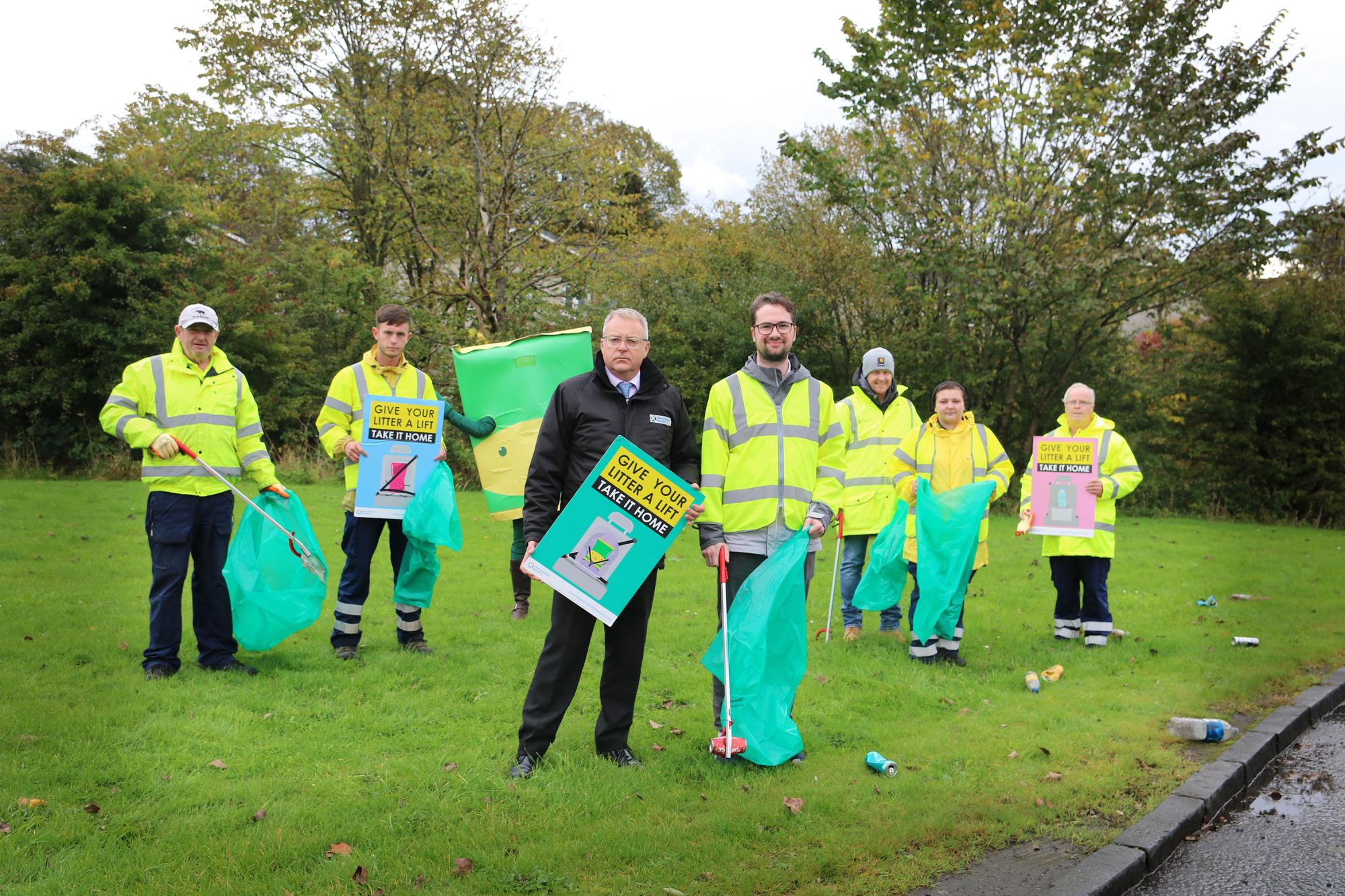 Councillor Paul Ferretti, Convener of the Council’s Place, Neighbourhood and Corporate Assets Committee (centre, on the right) and Barry Fisher, CEO of Keep Scotland Beautiful (centre, left), and are pictured with Thomas McMenamin - Executive Officer Roads and Environment (third from right, back), Council officers and Wido the crisp packet.