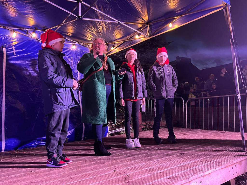 Provost on stage switching on lights